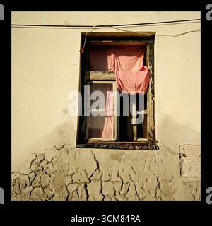A window with red gingham curtains on the Adriatic Coast Stock Photo