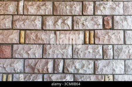 Rustic stone wall with multicolored natural rocks and mortar Stock Photo