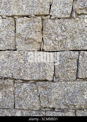 Rustic stone wall with multicolored natural rocks and mortar Stock Photo
