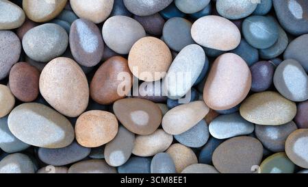 Pebbles stones on seashore as  texture background for design web banner template page. many stones and they are different in color and size, dry stone Stock Photo
