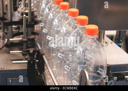 Transparent plastic bottles on a conveyor belt for bottling drinks Stock Photo