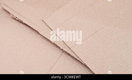 Stack of cardboard boxes with a white background. The boxes are cut in half and have a rough texture Stock Photo