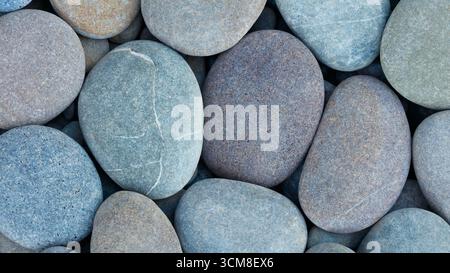 Pebbles stones on seashore as  texture background for design web banner template page. many stones and they are different in color and size, dry stone Stock Photo