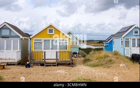 The famous colourful holiday beach huts and holiday homes at Hengistbury Head overlooking Christchurch harbour and the sea near Bournemouth UK Stock Photo