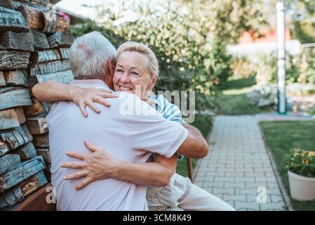 Happy senior couple embracing, spending time together at home during retirement. Stock Photo