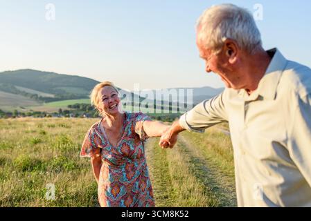 Elderly man and woman spending time in nature. Indian summer concept. Stock Photo