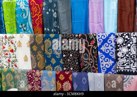 Vibrant selection of patterned and solid fabrics in various colors, ideal for fashion, interior design, and cultural textile concepts Stock Photo