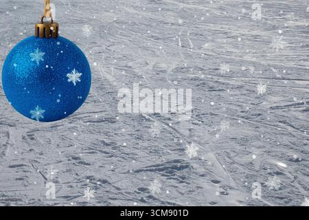 Blue Christmas ball decorated with snowflakes on snowy background. Festive winter ornament for holiday design, New Year and Christmas decoration Stock Photo