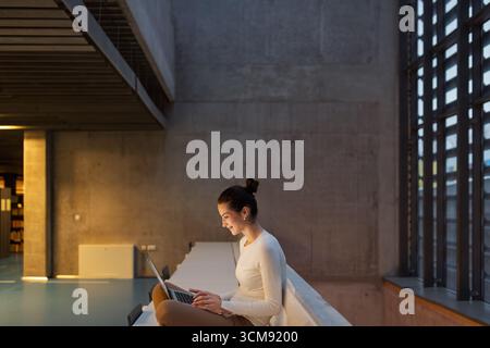 Businesswoman reading shocking report on laptop in office. Stock Photo