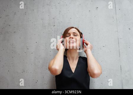 A portrait of young businesswoman, listening music. Stock Photo