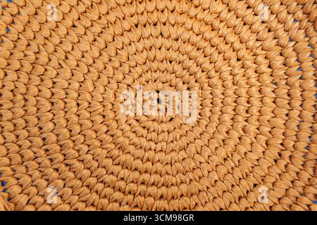 Circular weaving from natural raffia, close up. Stock Photo
