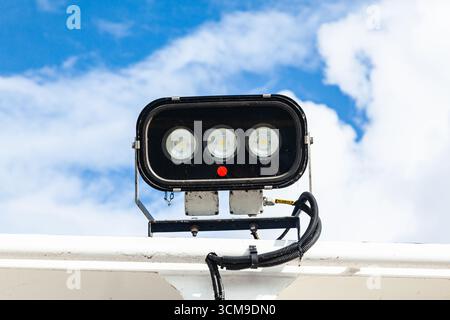 Industrial steel spotlight on a metal pole against a clear blue sky, close up Stock Photo