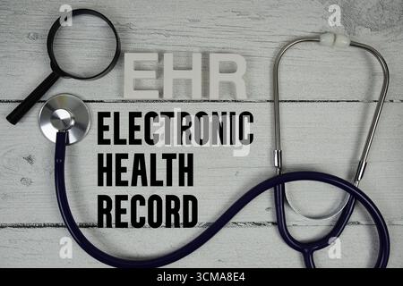 EHR Electronic Health Record text with Stethoscope on wooden background Stock Photo