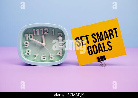 Set Smart Goals text and alarm clock on blue and purple background Stock Photo