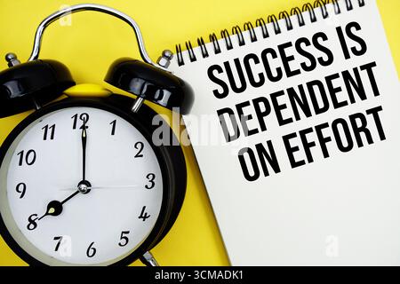 Success is Dependent on Effort text with alarm clock flat lay on yellow background Stock Photo