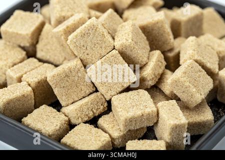 A brown sugar cubes closeup texture background natural sweetener organic ingredient healthy food macro shot rustic kitchen dessert preparation soft fo Stock Photo
