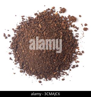 pile of dark brown compost soil with granular texture, loose pieces scattered around edges, isolated white background, taken from above Stock Photo