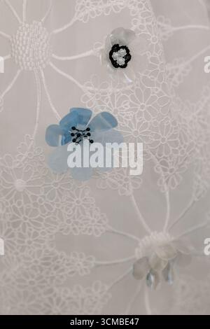 Beautiful lace displays intricate designs featuring blue and black flowers, creating an elegant textile pattern. Stock Photo