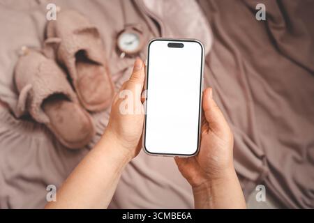 Phone with an isolated screen on the background of home clothes, a place for your text Stock Photo