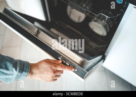 The choice of the eco mode of the dishwasher. Energy saving concept. Rational use of energy resources. Stock Photo