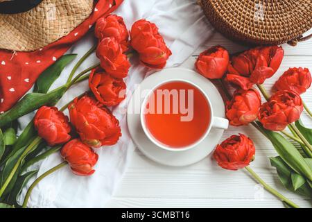 Beautiful spring composition, good morning concept. Cup of tea, peonies flat lay top view. Stock Photo