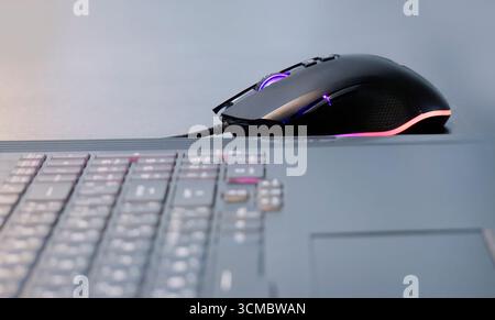 An illuminated gaming mouse, LED lights, colorful lights, wire mouse, digital gadget, fun time, e sport, gaming mouse concept, E Sport commercial Stock Photo
