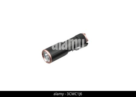 A compact black and copper-colored LED flashlight, isolated on a white background. Stock Photo