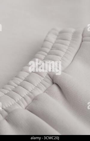 Warm grey tracksuit. Close-up of elastic waistband. Cotton. Pants. Macro photo. Stock Photo