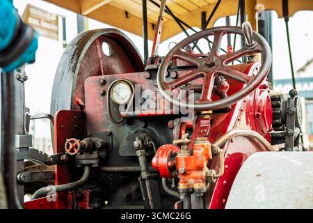 Drivers cockpit. Vintage steam engine operational panel with gauges, steering wheel, levers, and worn metal, highlighting industrial heritage in Irela Stock Photo