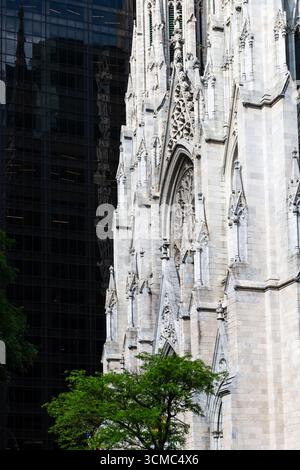 Close-up of St. Patrick’s Cathedral in New York City, showcasing its neo-Gothic architecture amid the modern skyscrapers of Midtown Manhattan. The int Stock Photo
