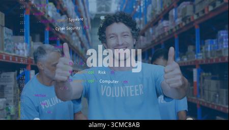 Smiling volunteer wearing blue T-shirt giving two thumbs up in warehouse with metal shelves Stock Photo