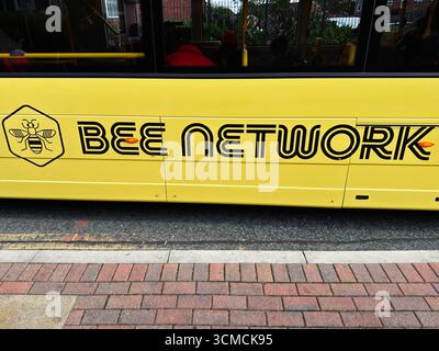 Manchester, UK - September 12, 2025: Yellow branded bus parked on roadside in Greater Manchester showcasing Bee Network design. Stock Photo
