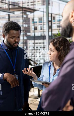 Diverse corporate staff gathered to brainstorm solutions together in the office, working to review reports for business growth. Workmates meeting and sharing insight on a successful strategy. Stock Photo