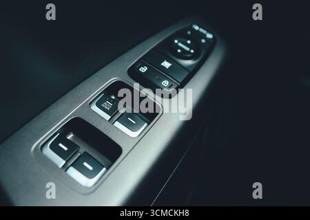 Interior of modern car. Side door buttons: window, mirror adjustment buttons, door lock. Car inside. Stock Photo