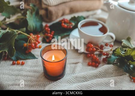 Burning candle in autumn interior. Stock Photo