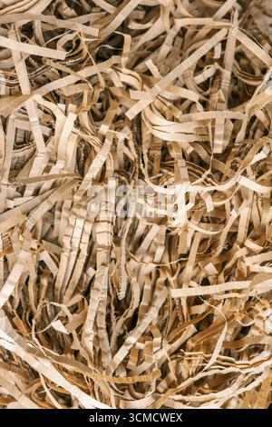 Beige color shredded paper . Gift box filler background. Stock Photo