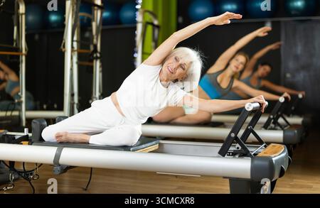 Elderly woman doing side bends Stock Photo