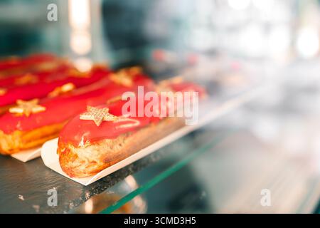 Freshly baked eclairs on display in a cafe. Stock Photo