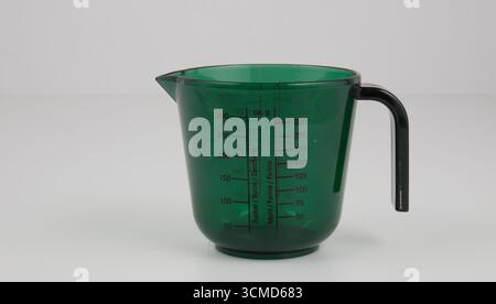Green measuring cup isolated nature background with clipping path Stock Photo