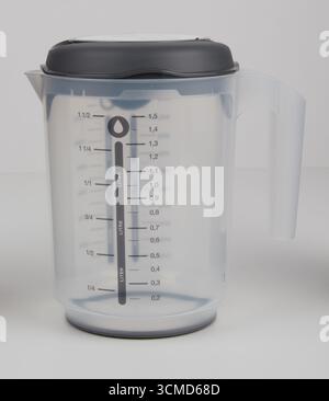 Clear plastic measuring cup with lid isolated nature background with clipping path Stock Photo