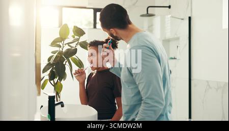 Child, dad and brushing teeth in bathroom for dental hygiene or morning routine together in home. Father, daughter and toothbrush with mirror or lens Stock Photo