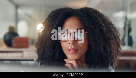 Thinking, reading and business woman on computer for gantt chart, article and night. Glasses, project management or African copywriter with reflection Stock Photo