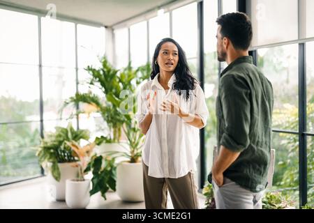 Happy young successful startup, business people of different human races chatting at office together Stock Photo