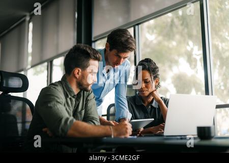 A diverse, talented team collaborates effectively in a bright office space during a business meeting Stock Photo