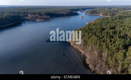 Aerial view of a serene lake surrounded by lush green hills and a ...