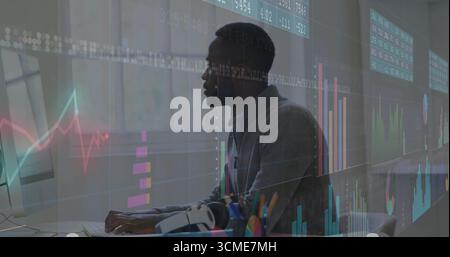 Typing male analyst analyzing transparent market charts on monitor at office desk, with keyboard Stock Photo