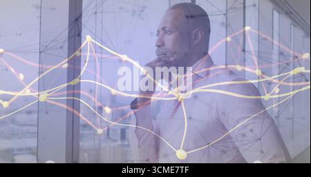 Gazing mature businessman resting hand on chin at office glass window, digital network overlay Stock Photo