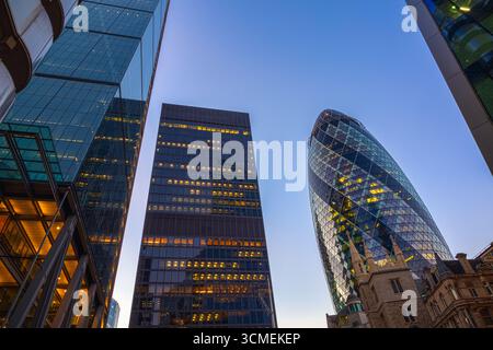 A view of modern London skyscrapers at dusk, featuring high-rises The Gherkin and St Helen's Stock Photo