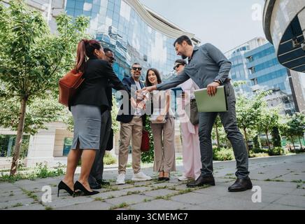 Group of colleagues collaborating together outdoors in a modern urban setting Stock Photo