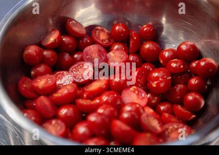 sliced ​​cherry tomatoes in an iron bowl Stock Photo